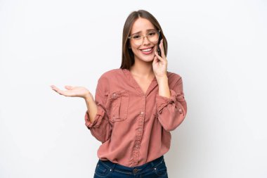 Young pretty caucasian woman isolated on white background keeping a conversation with the mobile phone with someone