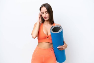 Young beautiful sport woman going to yoga classes while holding a mat isolated on white background with headache