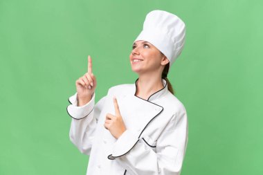 Genç aşçı kadın izole edilmiş yeşil arka plan 