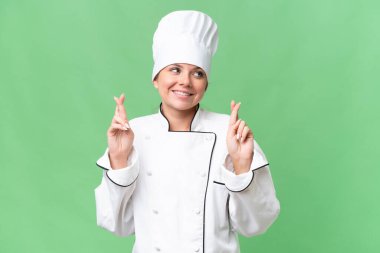 Genç aşçı kadın izole edilmiş yeşil arka plan 