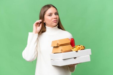 Sarışın, güzel bir kadın, yiyecekleri soyutlanmış arka planda tutuyor. Şüpheleri var.