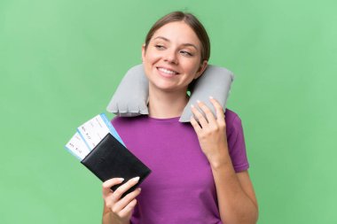 Young beautiful blonde woman with Inflatable travel Pillow over isolated background posing with arms at hip and smiling