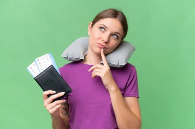 Young beautiful blonde woman with Inflatable travel Pillow over isolated background having doubts