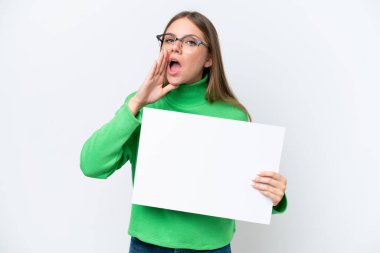 Beyaz arka planda izole edilmiş beyaz bir kadın boş bir levha tutuyor ve bağırıyor.