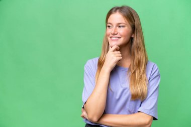 Young beautiful woman over isolated background looking to the side and smiling