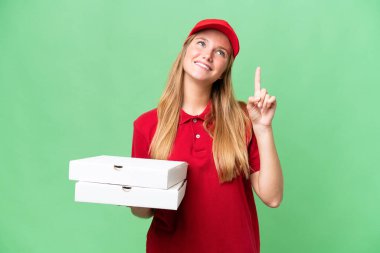 Young caucasian pizza delivery woman with work uniform picking up pizza boxes over isolated background pointing up a great idea