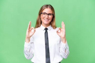 Young business caucasian woman over isolated background showing an ok sign with fingers