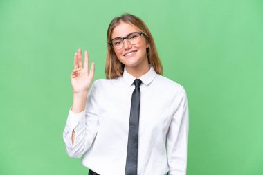 Young business caucasian woman over isolated background saluting with hand with happy expression