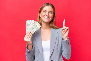 Kafkasyalı genç bir kadının elinde kırmızı arka planda izole edilmiş para olması harika bir fikre işaret ediyor.