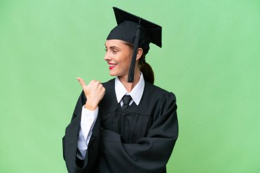 Young university graduate  caucasian woman over isolated background pointing to the side to present a product