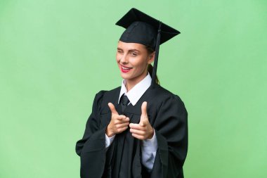 Young university graduate  caucasian woman over isolated background pointing to the front and smiling