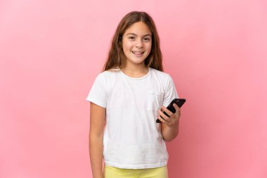 Child over isolated pink background using mobile phone