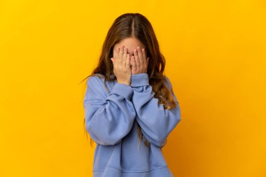 Çocuk yorgun ve hasta bir ifadeyle izole edilmiş sarı arka plan