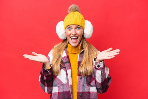 Young Beautiful Woman Wearing Winter Muffs Isolated Red Background Shocked — Stockfoto
