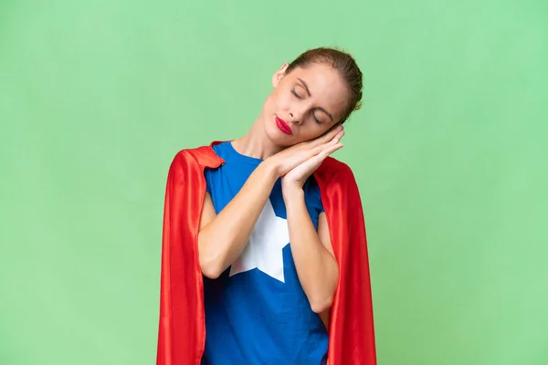 Super Hero caucasian woman over isolated background making sleep gesture in dorable expression