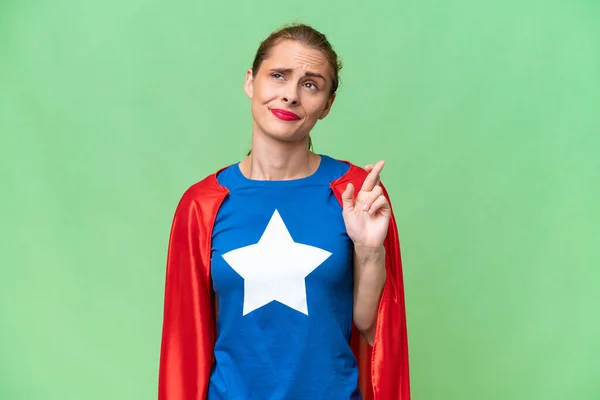 Super Hero caucasian woman over isolated background with fingers crossing and wishing the best