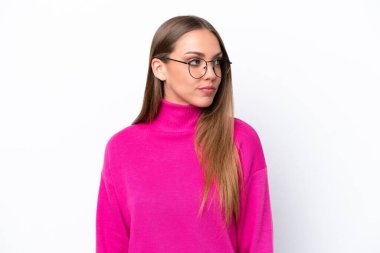 Beyaz arka planda izole edilmiş genç beyaz kadın yan tarafa bakıyor.