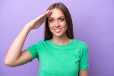 Mor arka planda izole edilmiş beyaz bir kadın. Mutlu bir ifadeyle selamlıyor.