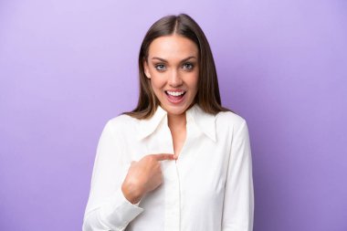 Mor arka planda yüzü sürpriz bir ifadeyle izole edilmiş beyaz bir kadın.