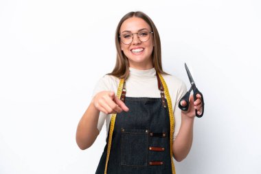 Young seamstress woman isolated on white background pointing front with happy expression