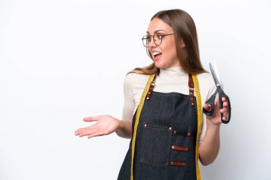 Young seamstress woman isolated on white background with surprise expression while looking side
