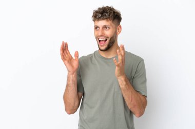 Beyaz arka planda yüzü şaşırmış, beyaz tenli yakışıklı genç bir adam.