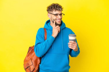 Sarışın genç öğrenci, sarı arka planda izole edilmiş bir şekilde bir fikir ararken...