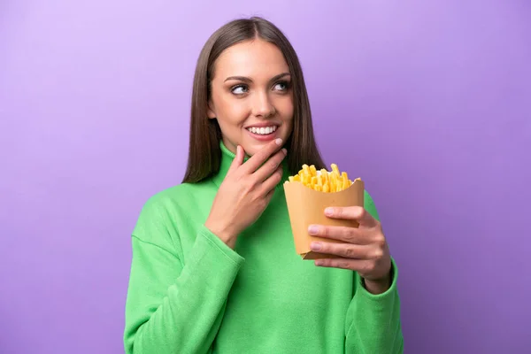 Young Caucasian Woman Holding Fried Chips Purple Background Looking While — Stockfoto