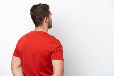 Beyaz arka planda izole genç beyaz adam arka pozisyonda ve geriye bakıyor