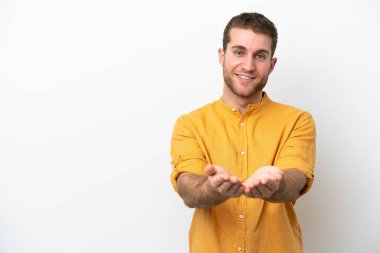 Beyaz arka planda izole edilmiş genç beyaz bir adam bir ilan vermek için avucunun içinde hayali bir fotokopi makinesi tutuyor.