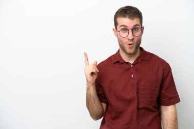Beyaz arka planda izole edilmiş genç beyaz bir adam çözümü bulmak için parmağını kaldırıyor.