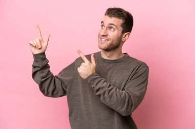 Pembe arka planda izole edilmiş genç beyaz adam işaret parmağıyla işaret etmek harika bir fikir.