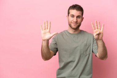 Young caucasian man isolated on pink background counting nine with fingers