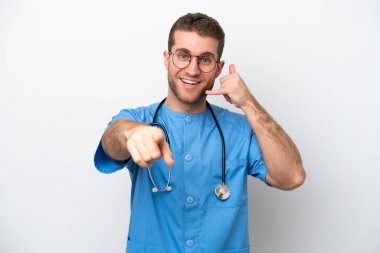 Young surgeon doctor caucasian man isolated on white background making phone gesture and pointing front