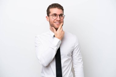 Young business caucasian man isolated on white background thinking an idea while looking up