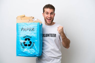 Beyaz arka planda izole edilmiş bir şekilde geri dönüşüm için kağıt dolu bir torba tutan beyaz bir adam zaferi kutluyor.