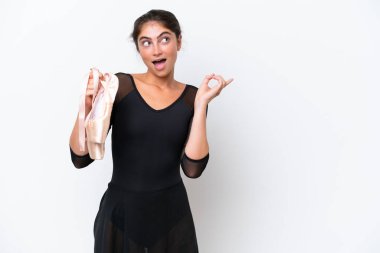 Beyaz arka planda bale yapan beyaz bir kadın çözümü bulmak için parmağını kaldırarak bale yapıyor.