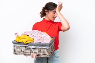 Young caucasian woman holding a clothes basket isolated on white background has realized something and intending the solution