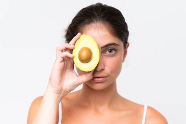 Beyaz arka planda izole edilmiş, elinde avokado tutan beyaz bir kadın. Portreyi kapat