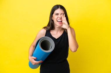 sport Italian woman going to yoga classes isolated on yellow background shouting with mouth wide open