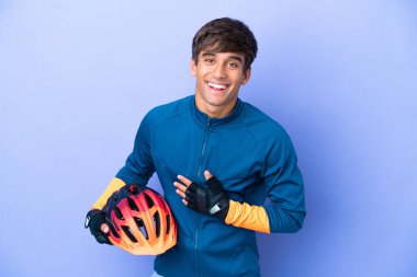 Mor arka planda izole edilmiş genç beyaz adam çok gülümsüyor.