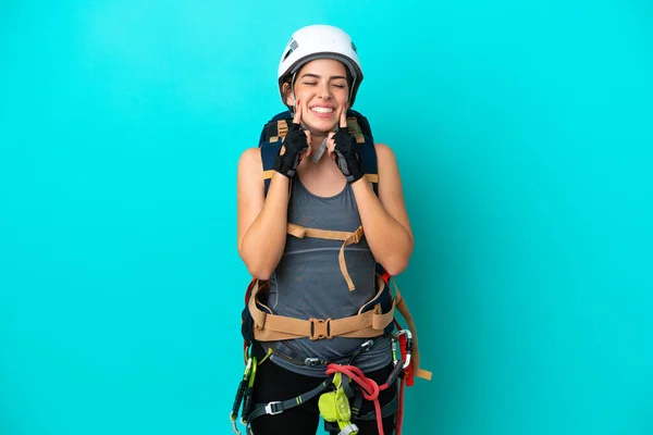 Young Italian rock-climber woman isolated on blue background smiling with a happy and pleasant expression