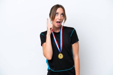 Young caucasian woman with medals isolated on white background thinking an idea pointing the finger up