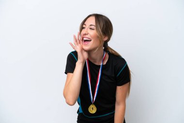 Young caucasian woman with medals isolated on white background shouting with mouth wide open to the lateral