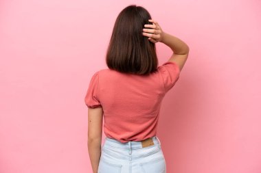 Genç Ukraynalı kadın pembe arka planda izole edilmiş ve düşünüyor.