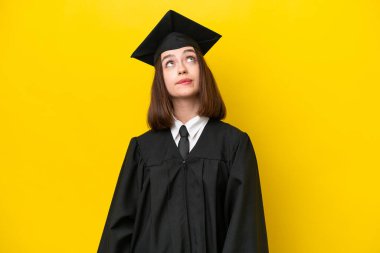 Genç üniversite mezunu Ukraynalı bir kadın sarı arka planda izole edilmiş ve araştırılıyor.