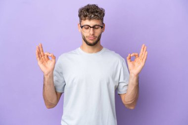 Delivery caucasian man isolated on purple background in zen pose