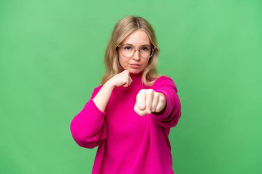 Young English woman over isolated background with fighting gesture