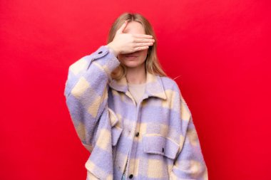 Young English woman isolated on red background covering eyes by hands. Do not want to see something