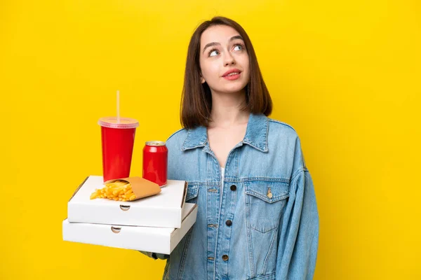 Young Ukrainian Woman Holding Fast Food Isolated Yellow Background Thinking — 스톡 사진